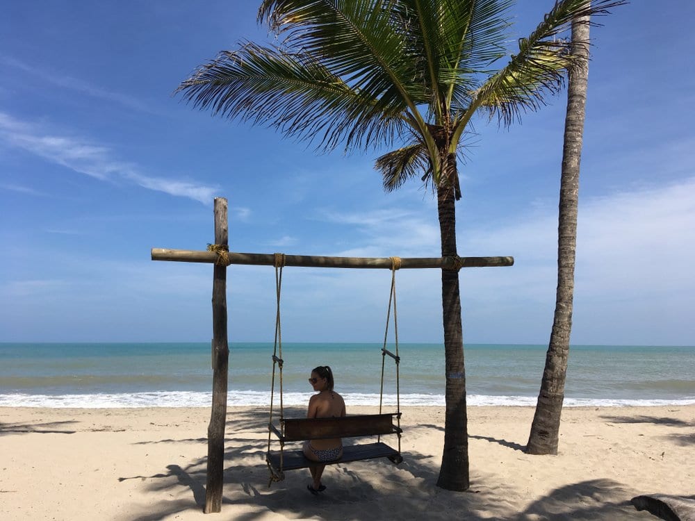 Tourist on swing on beach in Tayrona