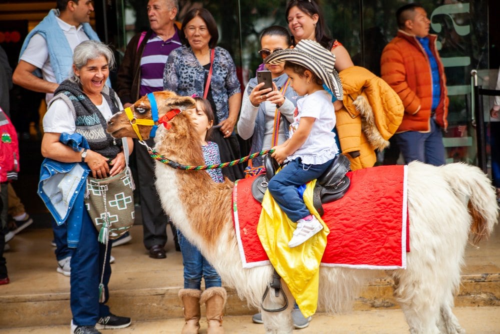 Kind op een lama in Bogota