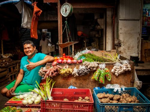 Lokale man met zijn groentenstand in de Bazurto Markt