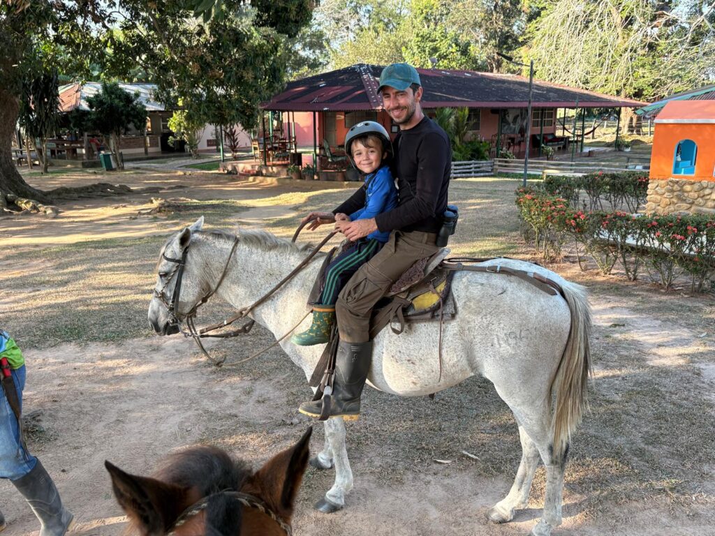 Kid and father on horse during holiday in Colombia